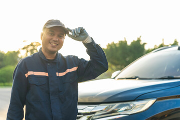 Happy asian automobile mechanic repairman wearing uniform, He standing and smiling to camera After...