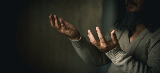 Man hand in prayer, expressing his religious faith in God through worship of Jesus Christ. Person man, turned to God in prayer, demonstrating their religious faith and devotion through worship.