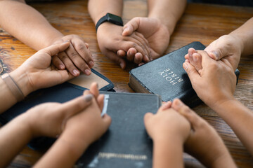 Woman joined hands with her faith group, coming together to pray as a team, unified in their...