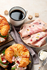 ..Croissant with ham and cheese on board and plate. Breakfast concept.