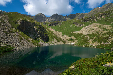 View of the Dukka lake "Rybka" on the Malaya Dukka River on the slopes of the Arkasar ridge in the North Caucasus on a sunny summer day, Arkhyz, Karachay-Cherkessia, Russia © Ula Ulachka