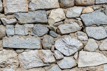 Stone wall made of a variety of rock sizes and colors from Himalayan field stones in India