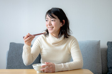 納豆ご飯を食べる若い女性