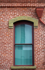 Old Red Brick Building with an Arched Window.

