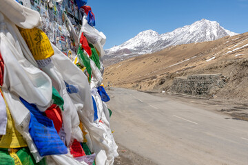 Colorful prayer flags alongside a high mountain pass route in the Indian Himalayas