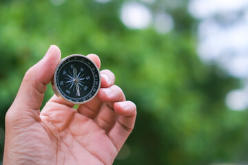 holding compass on tree mountain and sea blurry background. Using wallpaper or background travel or navigator image..