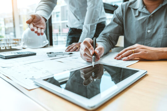 Engineer meeting and using digital tablet for architectural project and working with partner engineering on workplace