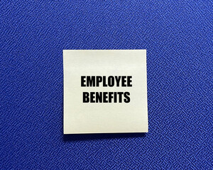 Words EMPLOYEE BENEFITS on yellow sticky note with blue background.