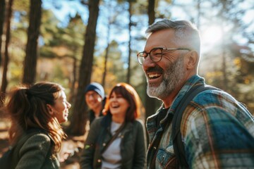 Group of friends walking in the forest. They are laughing and smiling.