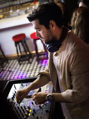 Male DJ playing music in club . Nightlife and disco concept.