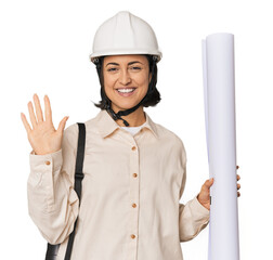 Young Caucasian female architect in studio smiling cheerful showing number five with fingers.