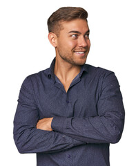 Young Caucasian man in studio smiling confident with crossed arms.