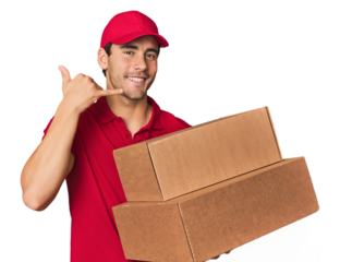 Young Hispanic delivery man with boxes showing a mobile phone call gesture with fingers.