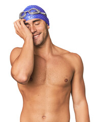 Young Hispanic man with swim gear laughing happy, carefree, natural emotion.
