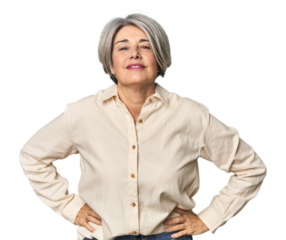 Caucasian mid-age female on studio background confident keeping hands on hips.