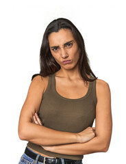 Hispanic young woman frowning face in displeasure, keeps arms folded.
