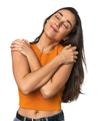 Hispanic young woman hugs, smiling carefree and happy.
