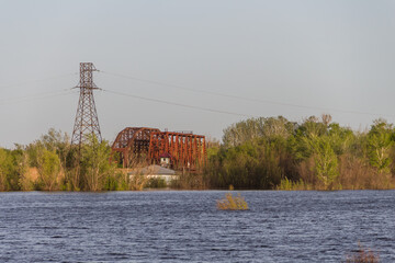 Iron cast iron railway bridge in Uralsk against the backdrop of large water after the flood. Flood...