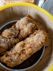 Top view of steamed dim sum, Deep-fried Beancurd Skin Roll in bamboo container.