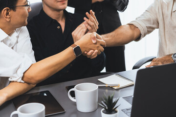 Diverse group of office employee worker shake hand after making agreement on strategic business...