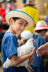 Little child happily playing with hen chicken outdoors, bringing joy and smiles