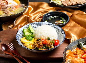 Pork Rice with tomato, cucumber, fork and spoon served in dish isolated on wooden board side view of asian food