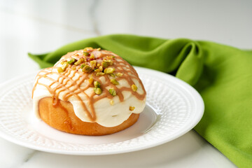 Cinnamon roll bun with icing on plate