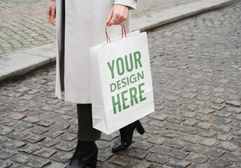 Mockup of woman with customizable paper shopping bag - obrazy, fototapety, plakaty