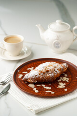 Almond Croissant on clay plate close up
