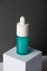 Blue glass cosmetic bottle, Skin care or sunscreen cosmetic on grey background.