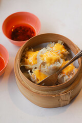 Chinese food. Dim sum topped with cheese with spicy sauce and chili oil.