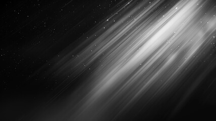 Monochrome image of light rays with dust particles, creating a sense of motion in darkness.