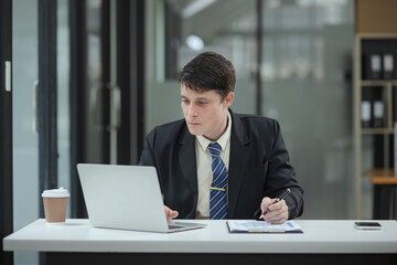 Fototapeta premium Professional business man trader using laptop computer sitting at office desk in modern office.