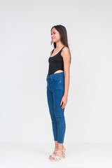 45 degree view of a young asian woman in a black bodysuit and jeans Isolated on a white background....