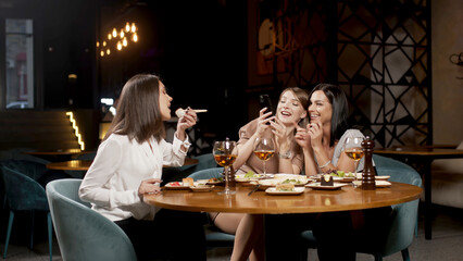 Positive girls best friends sitting in a cafe and chatting, colleagues partners gathered in a...