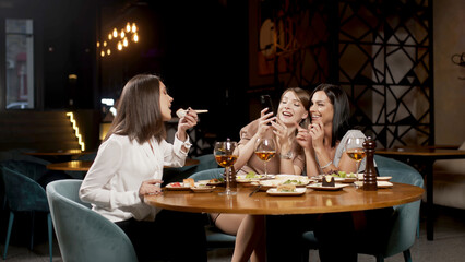 Positive girls best friends sitting in a cafe and chatting, colleagues partners gathered in a restaurant during lunch, talking, enjoying conversation, communication, good warm relationship concept