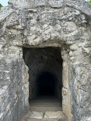 Old tunnel carved into the rock. Stone staircase leading down