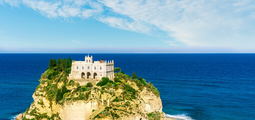 sea landscape of beautiful white temple or castle on a high cliff isle on a rock in crystal clear...