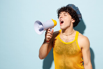 Young happy gay Latin man wear mesh tank top hat clothes scream in megaphone announces discounts...