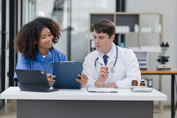 female African American doctor and doctor man working with clipboard in hospital.