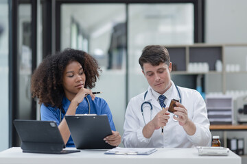 female African American doctor and doctor man working with clipboard in hospital.