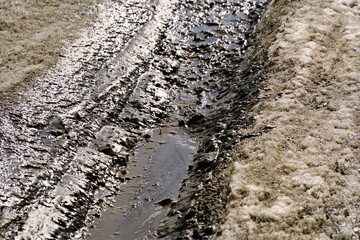 Car tracks on a dirty, damp road
