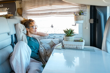 One woman relaxes inside a camper van motorhome rv vehicle. lady loves to relax sitting on the sofa...
