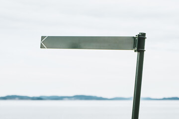 Clear Sky and Sea Frame the Blank Signpost