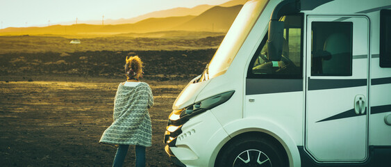 Travel and adventure living in a motorhome camper van people lifestyle. One woman standing outside...