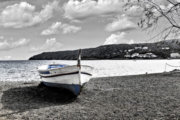 Typical fishing boat on the beach at sunset in the picturesque coastal town of Cadaqués, Costa Brava, Girona. black and white