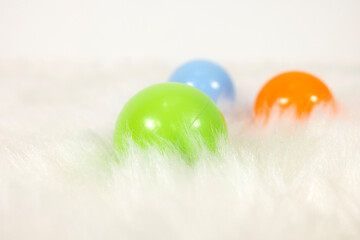 colorful toy balls on white plush carpet