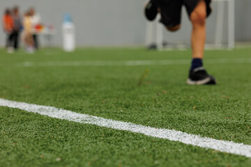 Green synthetic grass sports field with white diagonal line from above. Sports background for product display banner 