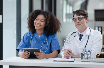 female African American doctor and doctor man working with clipboard in hospital.