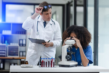 Medical science and microscope in laboratory for research concept. Two scientist with microscope...